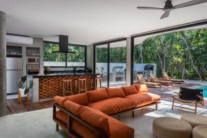 a living room with a couch and a kitchen at Luxury 4BR Eco Villa 10ppl Outdoor Pizza Oven - Private Pool & Jacuzzi in Tulum
