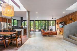 a kitchen and living room with a table and chairs at Luxury 4BR Eco Villa 10ppl Outdoor Pizza Oven - Private Pool & Jacuzzi in Tulum