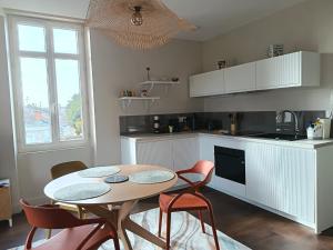 a kitchen with a table and chairs in a kitchen at La Tour Jayan in Agen