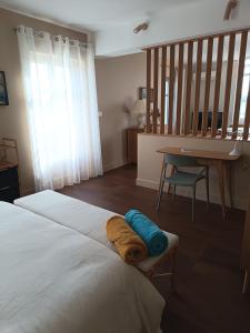 a bedroom with a bed and a table and a desk at La Tour Jayan in Agen