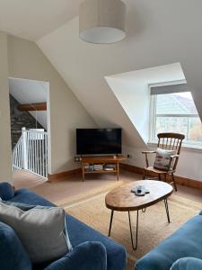 a living room with a couch and a tv at The Malt House, Portree in Portree
