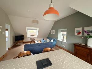 a living room with a blue couch and a table at The Malt House, Portree in Portree +25 photos