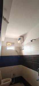 a bathroom with a toilet and a window at Spk grand hotel in Rushikonda