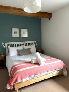 a bedroom with a bed with a red and white blanket at The Malt House, Portree in Portree