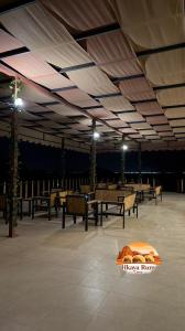 a pavilion with tables and benches and lights at Hkaya Rum camp in Disah +45 photos