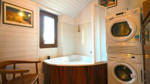 a bathroom with a tub and a washing machine at Maison Cozy Deco P0P' proche Paris in Villejust