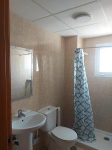 a bathroom with a toilet and a sink and a shower curtain at Apartamentos Residencial Duquesa in San Luis de Sabinillas