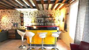 a yellow bar with white stools in a room at Maison Cozy Deco P0P' proche Paris in Villejust