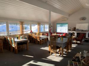 a dining room with tables and chairs and windows at Sæteråsen Hytter & Camping Trysil in Trysil