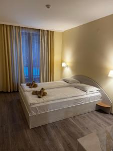 a bedroom with a large bed with two teddy bears on it at Forest Apartment/ Villa Park in Borovets
