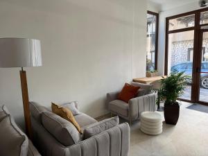a living room with two couches and a lamp at Hotel LUMIè Pescasseroli in Pescasseroli