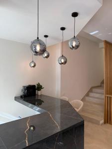 a kitchen with a black counter top and some lights at Hotel LUMIè Pescasseroli in Pescasseroli +65 photos