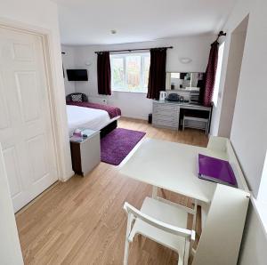 a bedroom with a bed and a desk and a table at The Stables B&B @ Pear Tree Cottage in Winslow