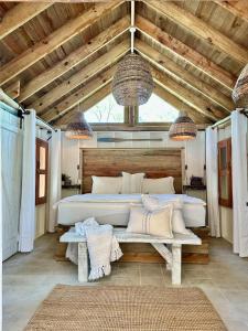 a bedroom with a large bed and a bench at Shipwreck Cove in Caye Caulker