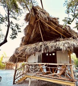 a hut with a thatched roof on a stand at Shipwreck Cove in Caye Caulker