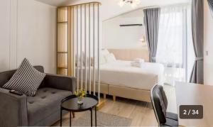 a hotel room with a bed and a couch at Ningle Place Hotel Pathumthani in Ban Pak Khlong Si +1 photo