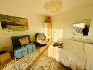 a bedroom with a bed and a chair at Fintra Bay Hideaway in Killybegs