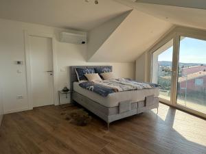 a bedroom with a bed and a large window at Marina Penthouse in Punat