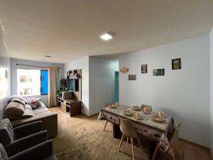 a living room with a couch and a table at Apartamento Mobiliado com internet e ar condicionado no centro in Cascavel