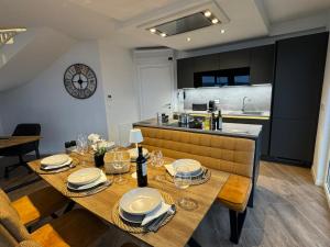 a dining room with a table and a kitchen at Marina Penthouse in Punat
