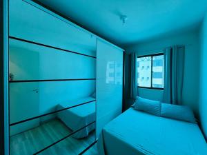 a blue room with a bed and a window at Apartamento Mobiliado com internet e ar condicionado no centro in Cascavel