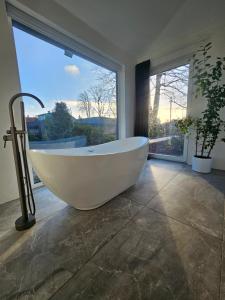 a bath tub in a bathroom with a large window at AMRAI Magnetic in Ventspils +29 photos