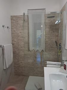 a bathroom with a shower with a stone wall at MaisonTuscany - Jacuzzi in Carrara +42 photos