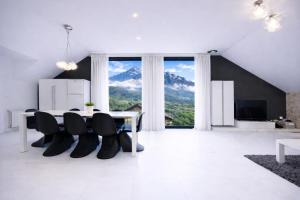 a dining room with a table and chairs and a large window at Casa Rural La Esencia in Araguás