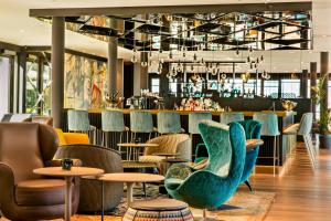 a lobby with chairs and a bar in the background at Motel One München-Messe in Munich +21 photos