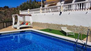 a swimming pool with a gazebo next to a house at Casa Verde Oliva in Sedella