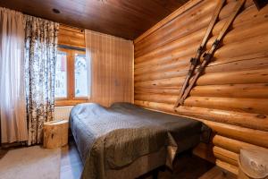 a bedroom with a bed in a wooden room at Levillenet Bearlodge at Levi city centre in Levi