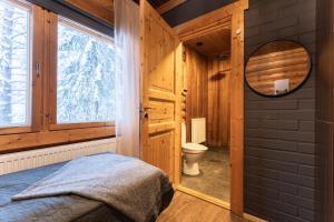 a bedroom with a bed and a toilet in a room at Levillenet Bearlodge at Levi city centre in Levi +39 photos