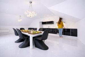 a woman standing in a kitchen with a table and chairs at Casa Rural La Esencia in Araguás +5 photos