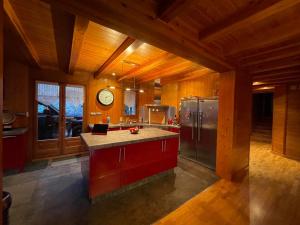 a kitchen with a stainless steel refrigerator and a clock at Les Bosquitos Chalet in Ax-les-Thermes
