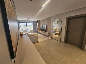 a hallway with a living room and a living room with a mirror at شقق باطلالات بانوراميه in Riyadh