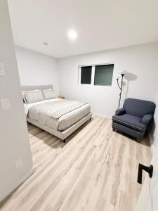 a bedroom with a bed and a couch and a chair at Private 1BR Suite with Kitchen, Laundry, Parking & 1 Gigabit Internet in Whitehorse