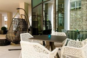 a table and chairs in front of a building at Motel One Stuttgart-Bad Cannstatt in Stuttgart
