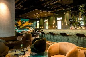 a restaurant with a bar with chairs and tables at Motel One München-East Side in Munich