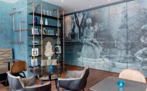 a dining room with a large painting on the wall at Motel One Stuttgart-Bad Cannstatt in Stuttgart