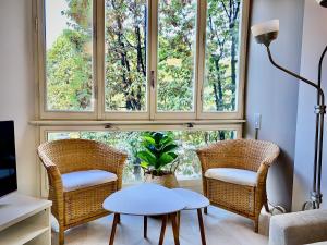 a living room with two chairs and a table and a window at Anna Home Gallarate train station to Milan Malpensa self-check-in in Gallarate