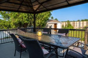 a table with chairs and a candle on a deck at Residence Havre d'abraham in Laval