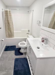 a white bathroom with a toilet and a sink at Private 1BR Suite with Kitchen, Laundry, Parking & 1 Gigabit Internet in Whitehorse +25 photos