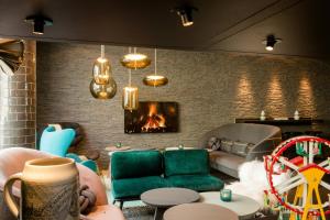 a living room with a couch and a fireplace at Motel One München-Westend in Munich