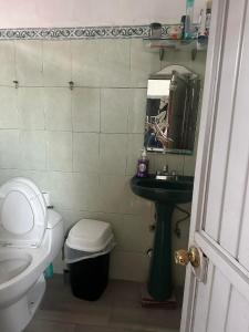 a bathroom with a toilet and a sink and a mirror at Cuarto a 4min del aeropuerto in Guadalajara +1 photo