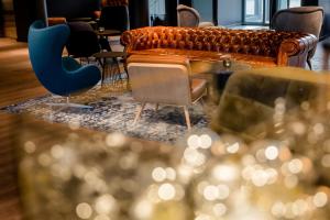 a room with chairs and a couch and tables at Motel One Stuttgart-Feuerbach in Stuttgart +28 photos