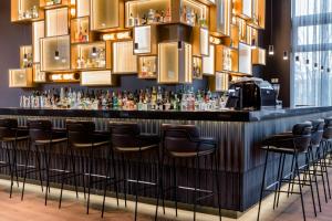 a bar in a restaurant with stools at Motel One Stuttgart-Feuerbach in Stuttgart