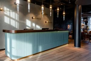 a bar in a restaurant with lights on the wall at Motel One Stuttgart-Feuerbach in Stuttgart