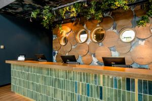 a lobby with a counter with chairs and mirrors at Motel One Wiesbaden in Wiesbaden