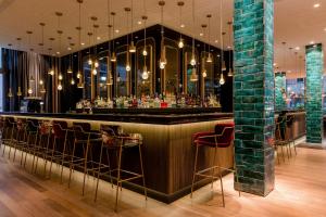 a bar in a restaurant with stools at Motel One München-Haidhausen in Munich