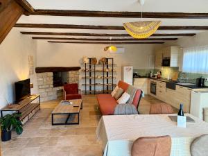 ein Wohnzimmer mit Sofa und Tisch in der Unterkunft Gîte Juno in Aubignan
